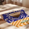 Roll of paper with blue and orange design on a wooden surface