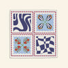 The Poppy Tile Milan Napkin by Good Juju Homeware features four abstract patterns in blue, red, white, and green with a red and white checkered edge, adding charm reminiscent of vibrant Poppy Tile prints to any outfit.