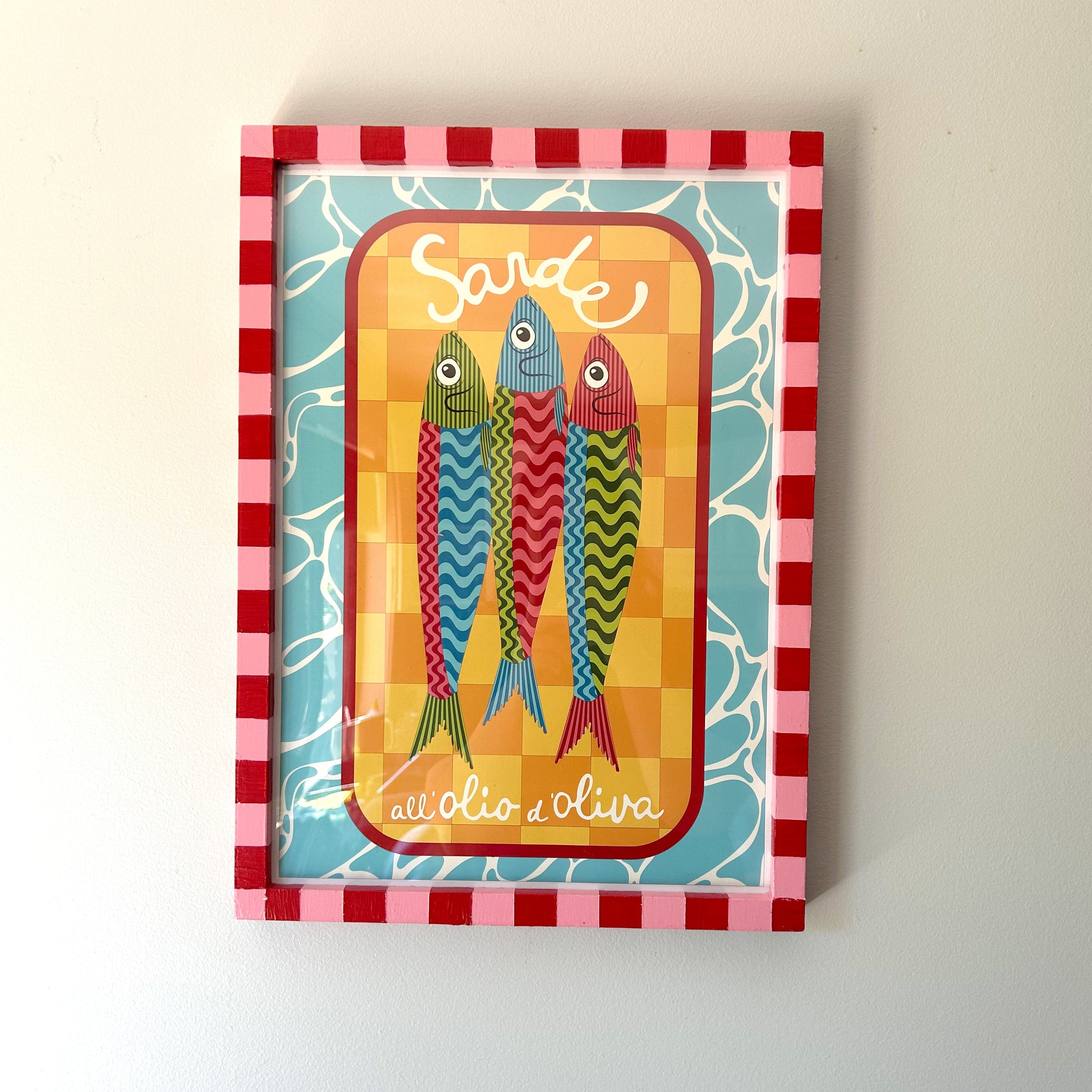 Decorative box with colorful fish illustration and 'Sarde' text on a checkered border.