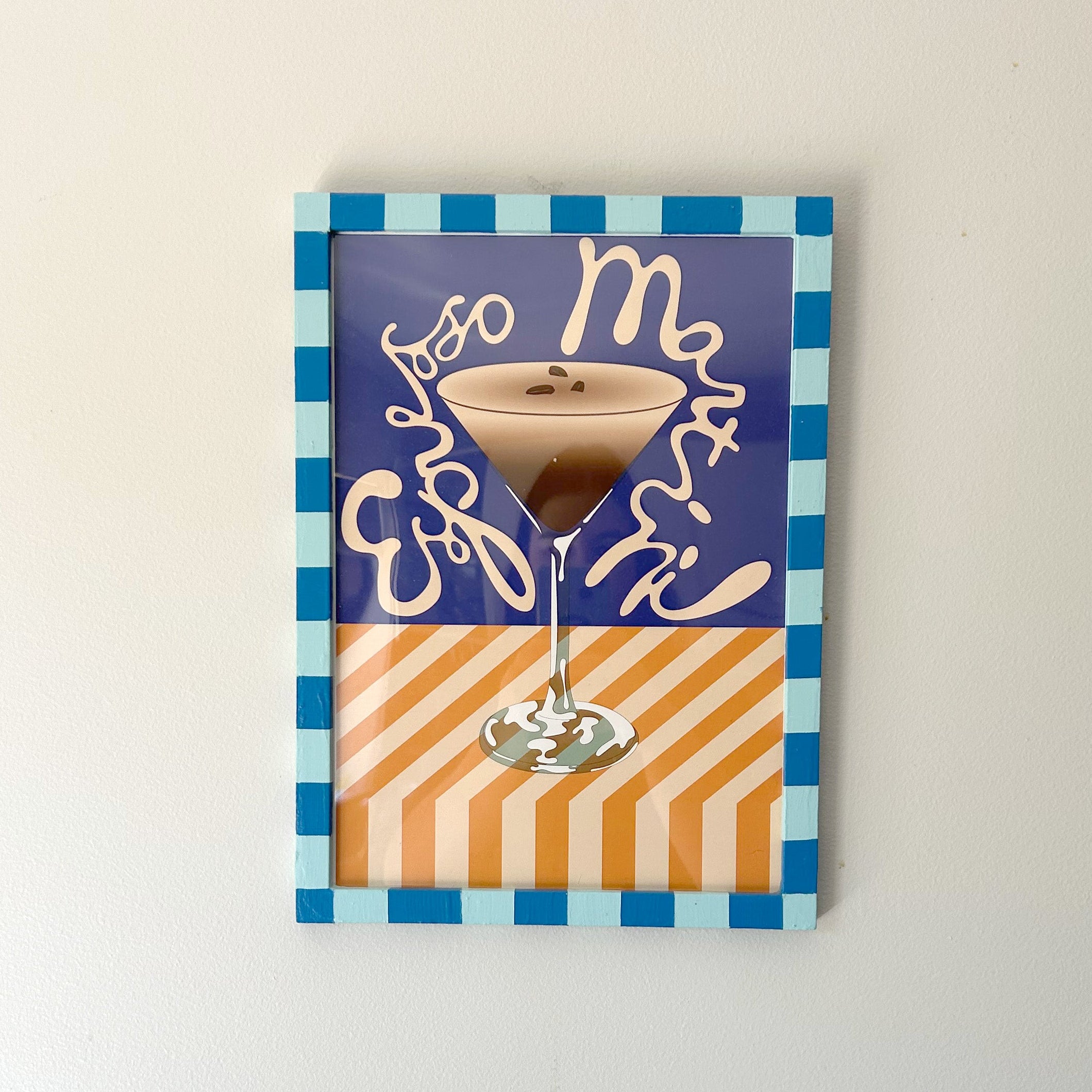 Decorative wall art with a coffee cup design on a checkered background