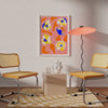 Two yellow chairs face each other, with a captivating Poppies All Around Capri Wall Art by Good Juju Homeware on the wall. A wavy floor lamp, geometric rug, and a vase on a small square table complete the setting.