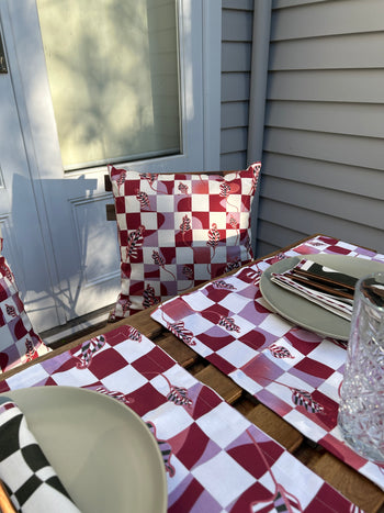 A red and white checkered placemat, designed by the Melbourne-based designer for Good Juju Homeware, has been replaced with The Checkered Calla Lily Pillow Case | Venice, designed by Good Juju Homeware.