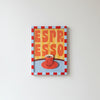The A4 Yellow and Butter Hand Painted Frame by Good Juju Homeware displays framed art of a red espresso cup marked "ESPRESSO," bordered by a red and blue checkered pattern, in a striped wooden frame hung on a white wall.