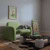 A living room with a green chair and a coffee table adorned with Calla Lillies in a Glass Vase Wall Art from Good Juju Homewares.