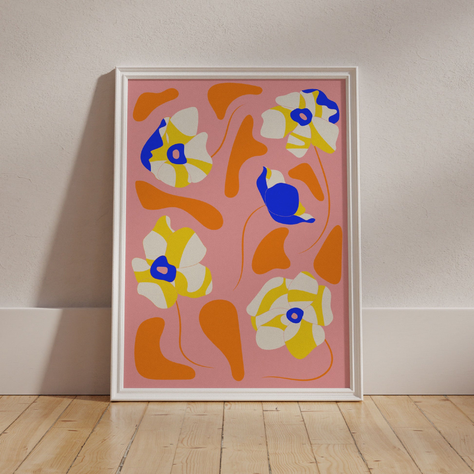 The Poppies All Around Capri Wall Art by Good Juju Homeware showcases blue, yellow, and white floral elements reminiscent of poppies on a pink background, elegantly leaning against a wooden floor.