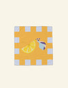 The Sunday Limone Napkin by Good Juju Homeware is a square towel featuring a yellow background, white border, printed lemon wedge reminiscent of the Italian sun, and small multicolored swirls.