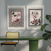 A modern room with a green table and chair accented by funky florals. Colorful art prints, such as "Poppies in a Glass Vase Venice Wall Art," adorn the walls, while a vibrant plant enlivens the corner. A touch of Good Juju Homeware completes the stylish atmosphere.