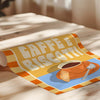 Decorative mat with coffee cup design and 'Caffè e Biscotti' text on a wooden surface.