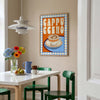 Dining room with a table, chairs, and a colorful 'Cappuccino' poster on the wall.